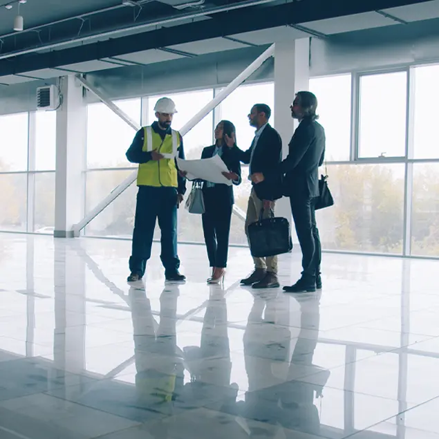 Atria team and investors touring active apartment construction site with hard hats