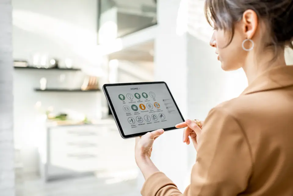Woman using smart home technology in modern Atria apartment