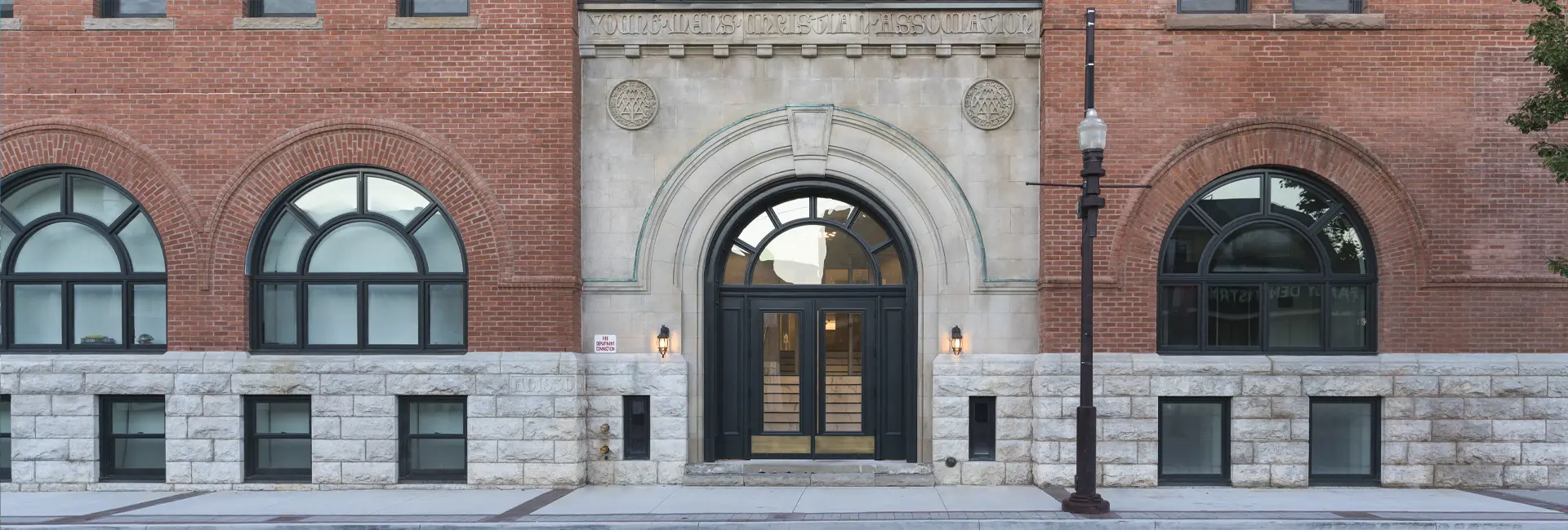 Front entrance of Y Lofts apartments for rent in downtown Peterborough featuring historic architecture